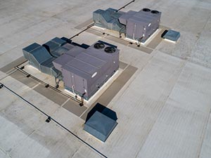Roof-Maintenance-Kettering-OH-Ohio-1 | A.H. Sturgill Roofing Rooftop HVAC units arranged on elevated platforms on a flat concrete roof, with ductwork nearby.